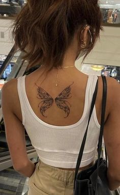 a woman with a butterfly tattoo on her back