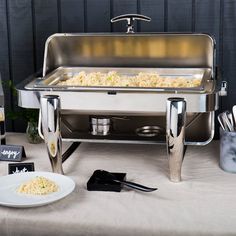 a buffet table with food and utensils on it, ready to be served