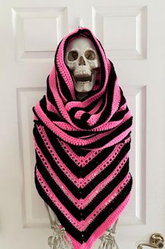 a skeleton wearing a pink and black crocheted shawl