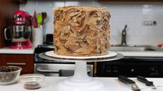 a cake sitting on top of a white plate next to bowls and utensils