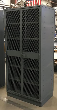 two large metal storage cabinets sitting in a warehouse with american flag on the wall behind them