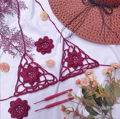 the crocheted triangle is next to some flowers