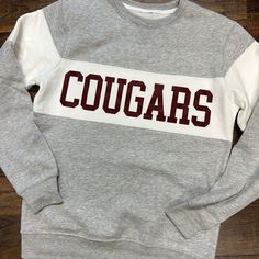 Show off your school pride with a custom School Spirit sweatshirt! This crew neck design is perfect for any die-hard fan. With the addition of color blocked detailing, and your school mascot printed on the front, it's an incredibly fashionable way to show your support. Whether you're at a game or walking around campus, wearing this custom piece will make sure everyone knows just how much you love your school! Perfect for any occasion where you need to make a statement about your school spirit. * Basketball Fan Shirts, Soccer Hoodies, Hoodie Customize, Sports Items, Personalized Cross, Baby Bandana Bibs, Senior Gifts, School Pride, Spirit Wear