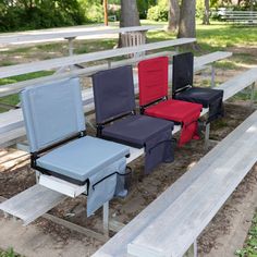 four folding chairs sitting next to each other on a park bench