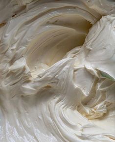 whipped cream in a white bowl with a green spatula on the side, ready to be mixed