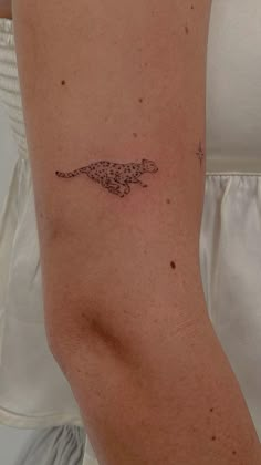 a woman's arm with a small tattoo of a cheetah