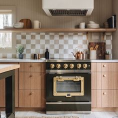 a stove top oven sitting inside of a kitchen next to wooden cabinets and counter tops