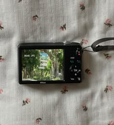 a digital camera sitting on top of a bed