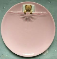 a pink plate with a teddy bear on it