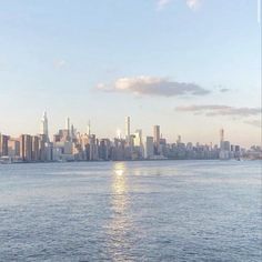 the city skyline is seen from across the water in this photo taken on a sunny day