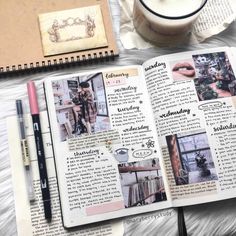 an open book on top of a table next to a cup of coffee and pen