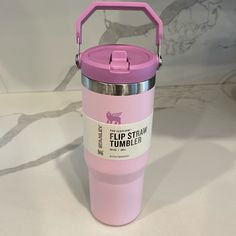 a pink tumbler cup sitting on top of a counter