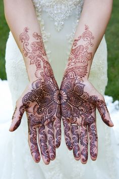 two hands with henna designs on them