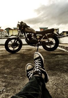 a person with their feet up in front of a motorcycle