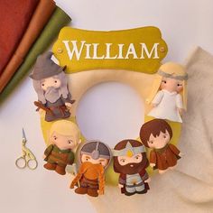 a wreath made out of paper with small figurines on it and the name william