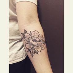 a woman's arm with a flower tattoo on the left side of her arm