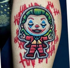 a close up of a person's leg with a clown tattoo design on it