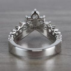 a silver ring with diamonds on it sitting on a table