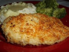 a red plate topped with chicken, mashed potatoes and broccoli