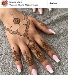 a woman's hand with henna tattoos on it