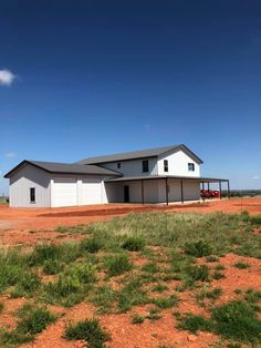 a large white building sitting on top of a dirt field