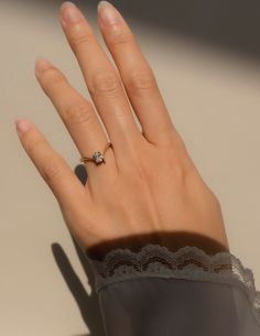 a woman's hand with a diamond ring on it