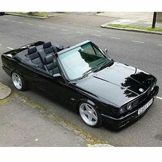 a black convertible car parked on the side of the road