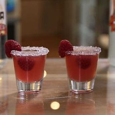 two glasses filled with raspberry margaritas on top of a table