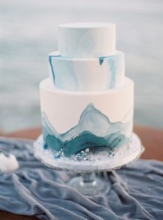 a white and blue cake sitting on top of a table