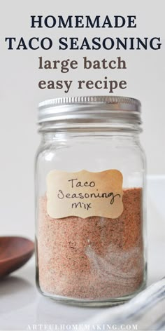 a jar filled with taco seasoning next to a spoon