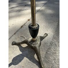 an ornate metal candle holder on the sidewalk