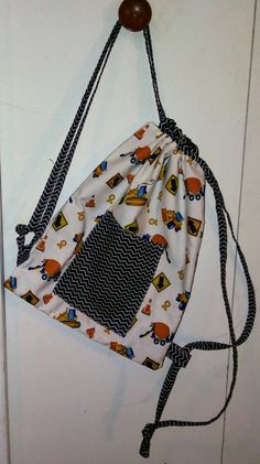 a drawstring bag hanging on the wall with a wooden hook in front of it