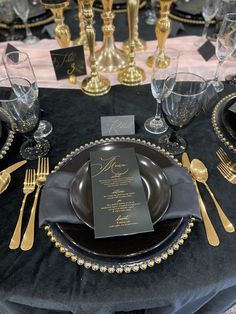 the table is set with black and gold place settings