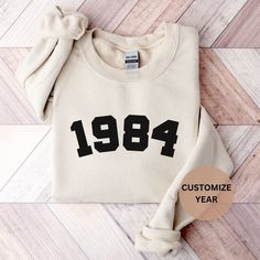 If you're looking for a unique and personalized birthday gift, a custom t-shirt, sweatshirt or hoodie is a great option! Add their name, birth date or a fun message to make it truly one-of-a-kind. They'll love wearing it on their big day and for years to come. Plus, it's a gift that's both practical and sentimental. So why not give them something they'll cherish forever with a custom birthday gift shirt, sweatshirt or hoodie?   🐱T SHIRT - The unisex soft-style t-shirt puts a new spin on casual Birthday Crew Neck Sweatshirt With Custom Text, Custom Text Crew Neck Sweatshirt For Birthday, 25th Birthday Gifts, Birthday Sweatshirt, Custom Birthday Gifts, 40th Birthday Gifts, Embroidered Sweatshirts, 40th Birthday, Everyday Look