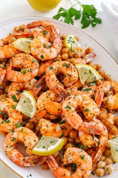 a white plate topped with shrimp and lemons