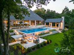 an aerial view of a backyard with a pool and patio furniture in the foreground