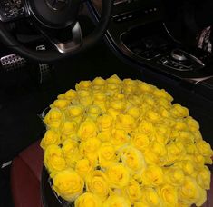 a bunch of yellow roses sitting in the center of a car