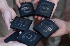 four people holding black flasks with white letters on them and the words zanck written in silver