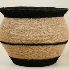 a black and tan striped basket sitting on top of a table