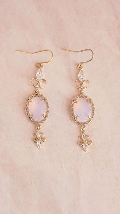 **All orders come with tracked shipping** Beautiful pair of handmade earrings with oval light pink stones surrounded by intertwined gold filigree work. It also has horseeye crystal rhinestones with unique gold curves. This pair of bridgerton style earrings are sure to stand out with any outfit. There are 2 jewelry box options: Box A: regular jewelry cardboard box with a textured diamond pattern on the outside (comes in white, black or red) Box B: Velvet earring and necklace box (comes in green, red and grey) You can also add a mini gift bag as show in the pics: comes with green, red or grey satin ribbon and a few sheets of gift tissue paper. Ready to ship in 1-3 business days Shipping time to Canada and U.S: 2 - 8 business days Need it within 2-3 business days? Please upgrade shipping at c Pink Victorian Earrings For Gift, Victorian Style Pink Earrings For Gift, Victorian Pink Earrings For Wedding, Victorian Style Pink Earrings For Wedding, Ornate Pink Wedding Jewelry, Art Deco Pink Jewelry For Wedding, Pink Oval Feminine Jewelry, Feminine Oval Pink Jewelry, Feminine Pink Oval Jewelry