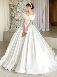 a woman in a white wedding dress posing for the camera