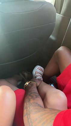 a man laying in the back seat of a car next to a woman wearing sandals