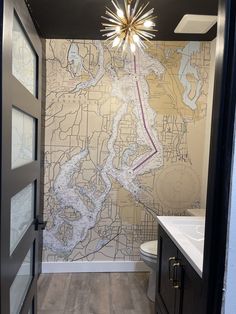 a bathroom with a map on the wall and a light hanging from the ceiling above it