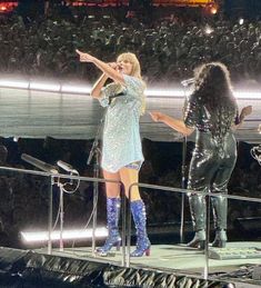 two women on stage with one pointing at the crowd