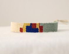 a bracelet made with multicolored beads on a white surface