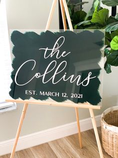 a sign that says the collins on it next to a potted green plant