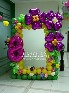 the balloon arch is decorated with flowers, balloons and an o - shaped number 6