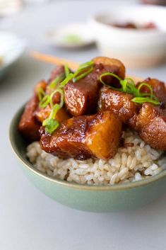 a bowl filled with rice and meat on top of a table