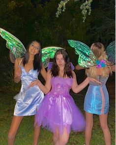 three girls dressed in fairy costumes posing for the camera