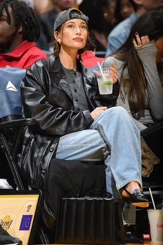 a woman sitting in a chair holding a drink